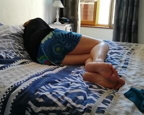 My wife's bare feet on the bed