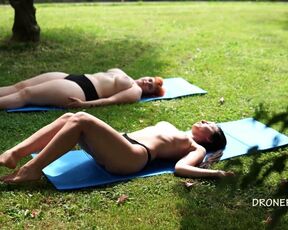 Two naked girls sunbathing in the city park